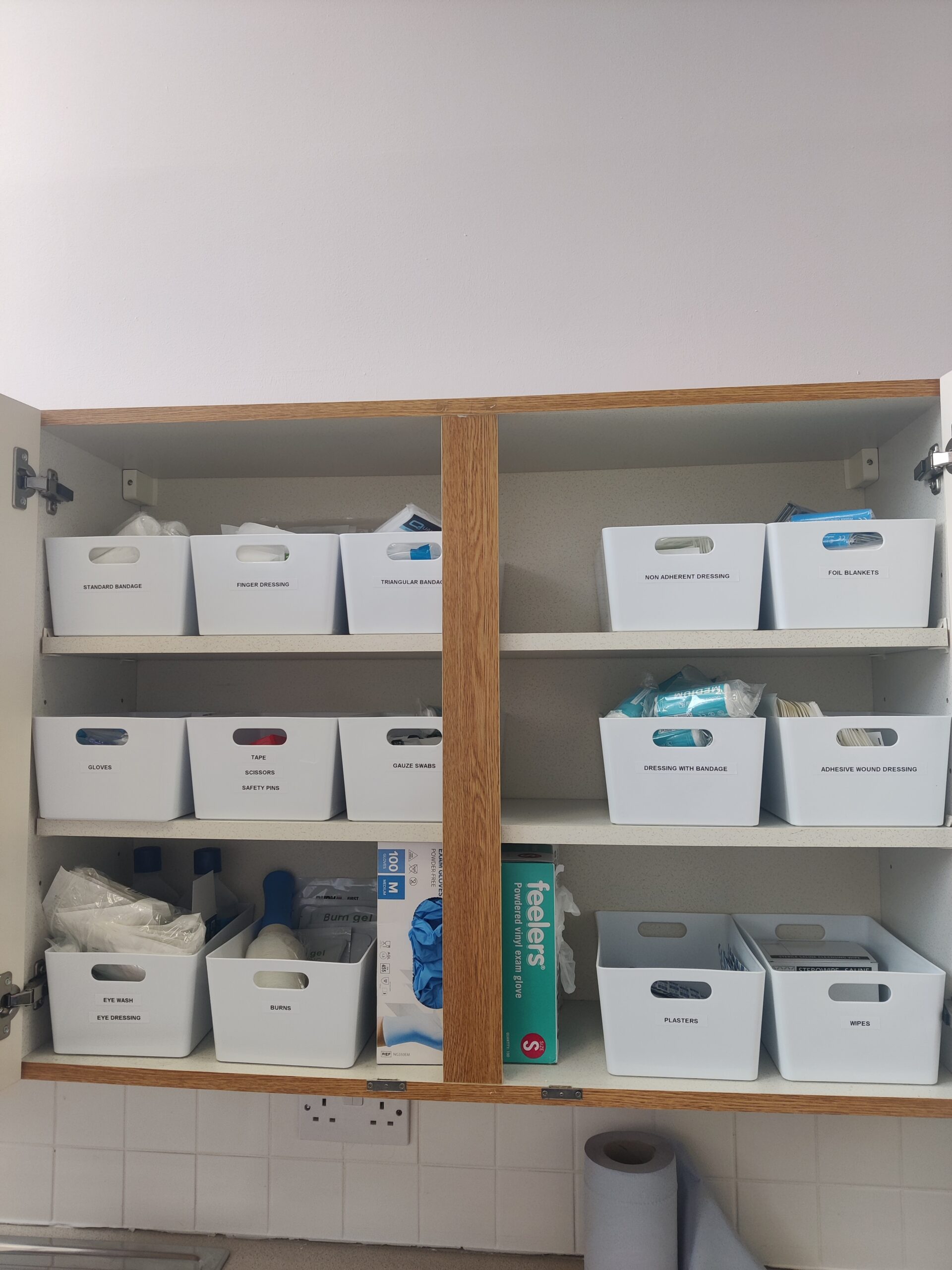 A medical cabinet with a lot of white boxes containing medical equipment.