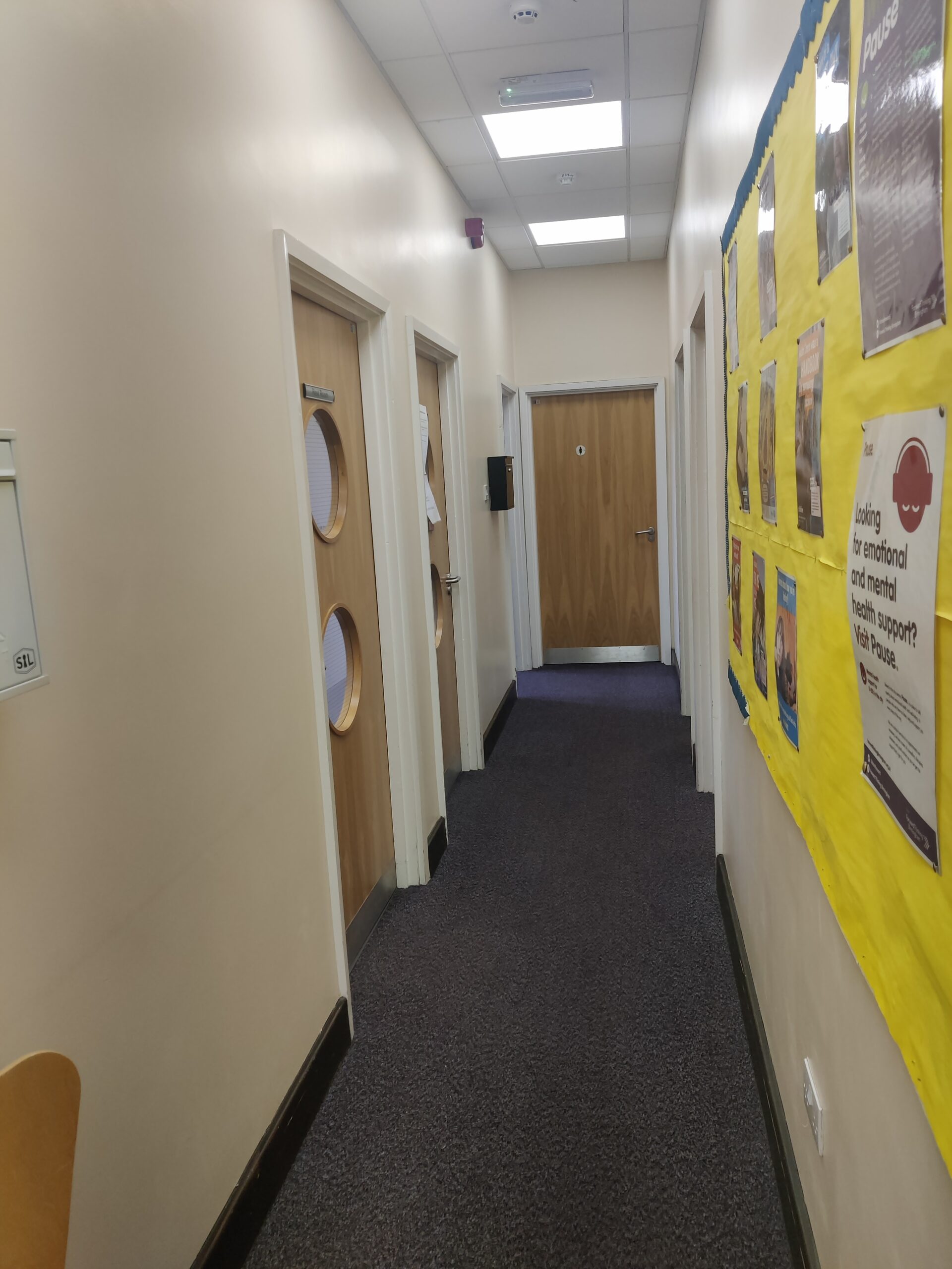 A hallway with posters and bulletin boards.